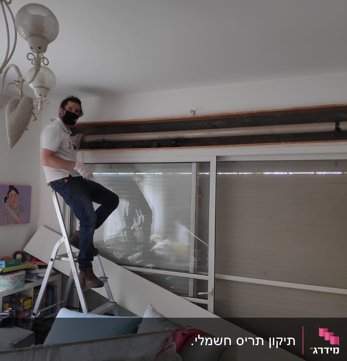 אדם על סולם מתקין תריסים בחלון גדול